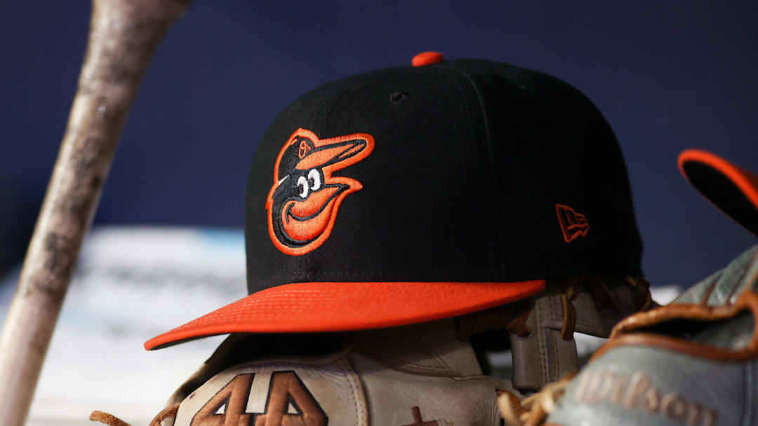 May 5, 2023; Atlanta, Georgia, USA; A detailed view of a Baltimore Orioles hat and glove in the dugout during a game against the Atlanta Braves in the seventh inning at Truist Park. Mandatory Credit: Brett Davis-Imagn Images
