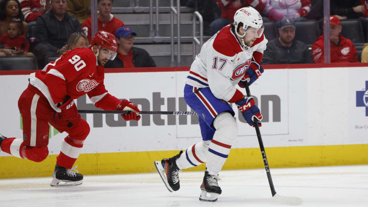 Apr 15, 2024; Detroit, Michigan, USA;  Montreal Canadiens right wing Josh Anderson (17) skates with the while puck chased by Detroit Red Wings center Joe Veleno (90) in the second period at Little Caesars Arena. Mandatory Credit: Rick Osentoski-USA TODAY Sports