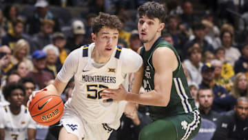 Nov 30, 2025; Morgantown, West Virginia, USA; West Virginia Mountaineers guard Treysen Eaglestaff (52) drives baseline past Mercyhurst Lakers guard Or Faran Frenkel (23) during the second half at Hope Coliseum. Mandatory Credit: Ben Queen-Imagn Images