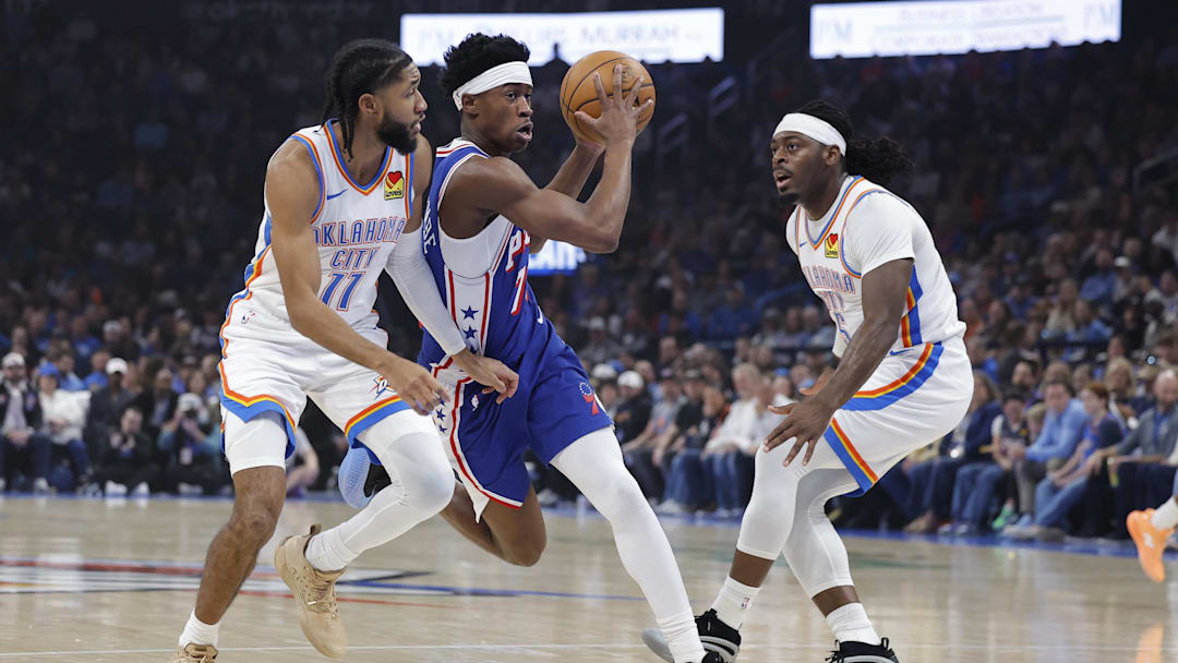 Dec 28, 2025; Oklahoma City, Oklahoma, USA; Philadelphia 76ers guard Vj Edgecombe (77) drives between Oklahoma City Thunder guard Isaiah Joe (11) and guard Luguentz Dort (5) during the first quarter at Paycom Center. Mandatory Credit: Alonzo Adams-Imagn Images Dec 28, 2025; Oklahoma City, Oklahoma, USA; Philadelphia 76ers guard Vj Edgecombe (77) drives between Oklahoma City Thunder guard Isaiah Joe (11) and guard Luguentz Dort (5) during the first quarter at Paycom Center. Mandatory Credit: Alonzo Adams-Imagn Images