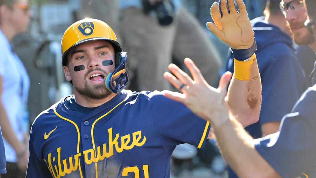 Oct 16, 2025; Los Angeles, California, USA; Milwaukee Brewers third baseman Caleb Durbin (21) celebrates in the dugout after scoring against the Los Angeles Dodgers in the second inning during game three of the NLCS round for the 2025 MLB playoffs at Dodger Stadium. Mandatory Credit: Jayne Kamin-Oncea-Imagn Images