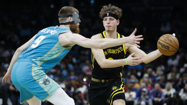 Mar 29, 2024; Charlotte, North Carolina, USA; Golden State Warriors guard Brandin Podziemski (2) passes around Charlotte Hornets forward Davis Bertans (9) during the second half at Spectrum Center. Mandatory Credit: Nell Redmond-USA TODAY Sports