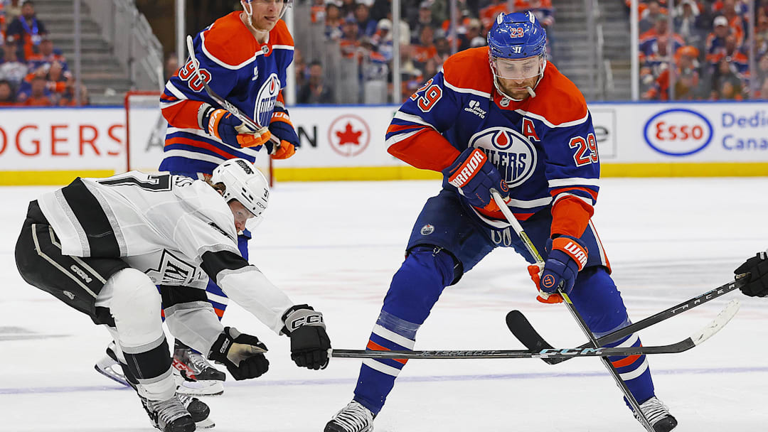 Apr 25, 2025; Edmonton, Alberta, CAN; Los Angeles Kings forward Warren Foegele (37) tries to knock the puck away from Edmonton Oilers forward Leon Draisaitl (29) during the third period in game three of the first round of the 2025 Stanley Cup Playoffs at Rogers Place. Mandatory Credit: Perry Nelson-Imagn Images