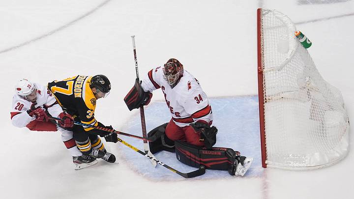 Aug 19, 2020; Toronto, Ontario, CAN; Boston Bruins center Patrice Bergeron (37) moves in for a shot against Carolina Hurricanes goaltender Petr Mrazek (34) and center Sebastian Aho (20) during the second period in game five of the first round of the 2020 Stanley Cup Playoffs at Scotiabank Arena. Mandatory Credit: John E. Sokolowski-USA TODAY Sports