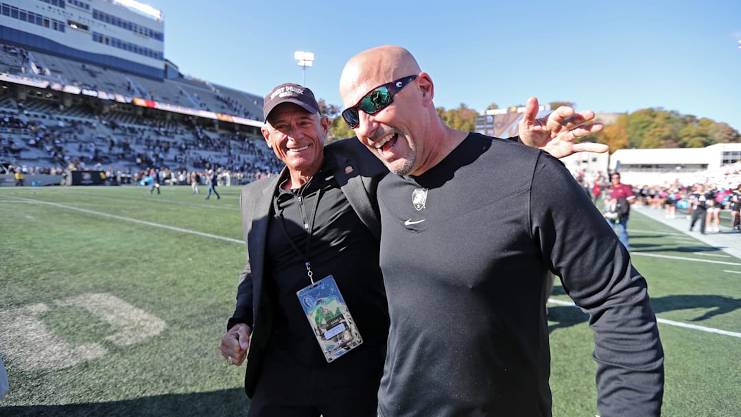 Oct 22, 2022; West Point, New York, USA; Army Black Knights offensive coordinator Brent Davis celebrates a win against the Louisiana Monroe Warhawks with former West Point superintendent Bob Caslen at Michie Stadium. Mandatory Credit: Danny Wild-Imagn Images