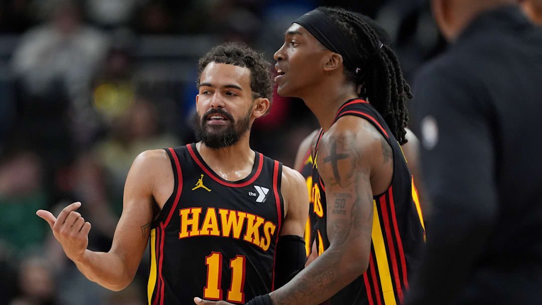 Trae Young #11 and Terance Mann #14 of the Atlanta Hawks talk during a break in action against the Milwaukee Bucks.