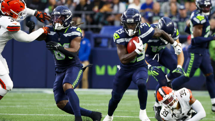 Aug 24, 2024; Seattle, Washington, USA; Seattle Seahawks wide receiver Dee Williams (33) returns a punt against the Cleveland Browns during the first quarter at Lumen Field. Seattle Seahawks cornerback Devon Witherspoon (21) blocks at left. Mandatory Credit: Joe Nicholson-USA TODAY Sports