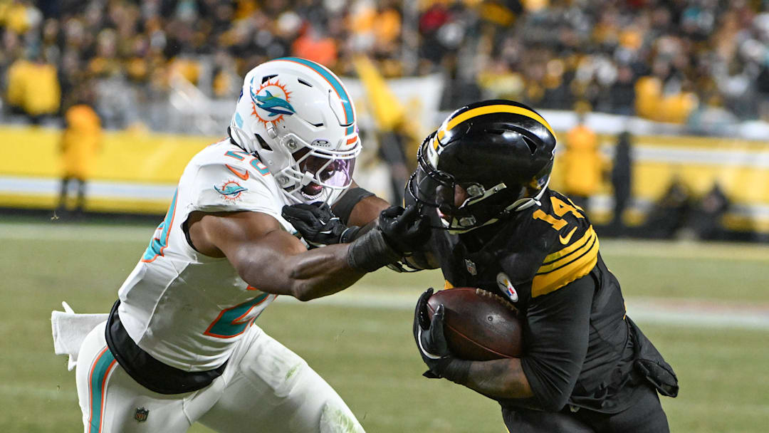 Dec 15, 2025; Pittsburgh, Pennsylvania, USA; Pittsburgh Steelers running back Kenneth Gainwell (14) fights off a tackle attempt by Miami Dolphins linebacker Jordyn Brooks (20) during the first half at Acrisure Stadium. Mandatory Credit: Barry Reeger-Imagn Images