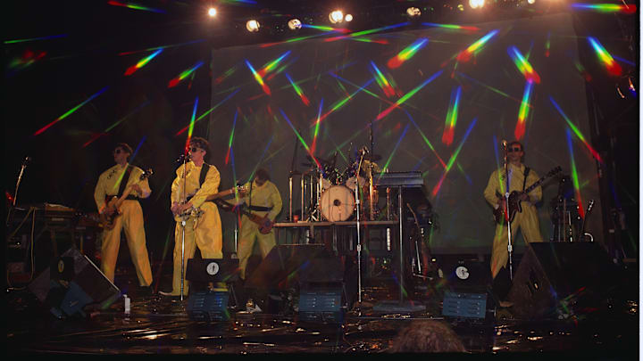 Devo Performing in Yellow Plastic Coveralls