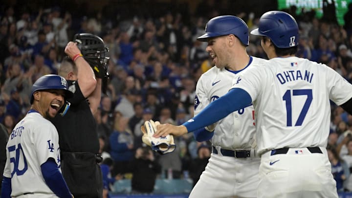 May 20, 2024; Los Angeles, California, USA;  Los Angeles Dodgers first baseman Freddie Freeman (5) is greeted at the plate by shortstop Mookie Betts (50) and designated hitter Shohei Ohtani (17) after hitting a grand slam home run in the third inning against the Arizona Diamondbacks at Dodger Stadium. Mandatory Credit: Jayne Kamin-Oncea-Imagn Images