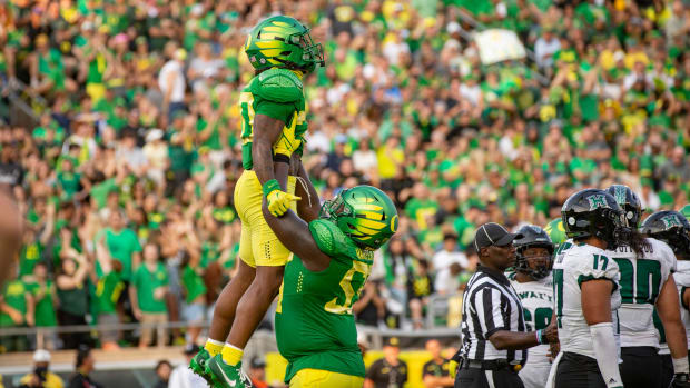 Oregon running back Jordan James is lifted into the air by teammate Marcus Harper II to celebrate a touchdown