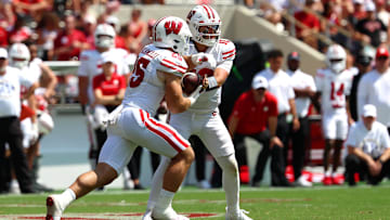 Sep 13, 2025; Tuscaloosa, Alabama, USA; Wisconsin Badgers quarterback Danny O'Neil (18) hands the ball off to running back Cade Yacamelli (25) during the second half against the Alabama Crimson Tide at Saban Field at Bryant-Denny Stadium. Mandatory Credit: David Leong-Imagn Images