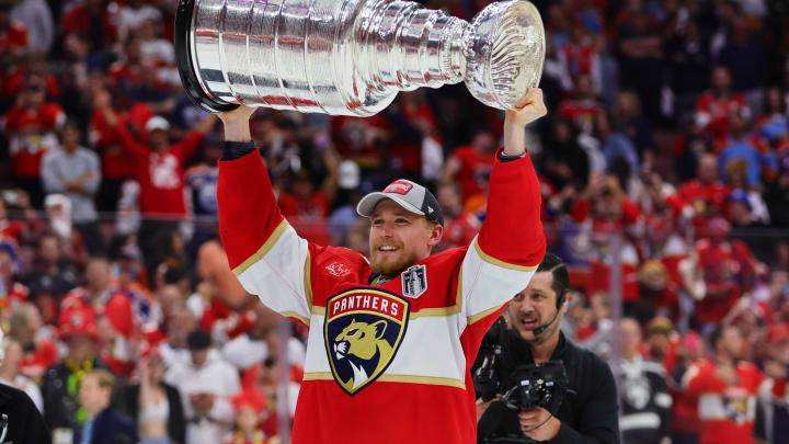 Jun 24, 2024; Sunrise, Florida, USA; Florida Panthers defenseman Gustav Forsling (42) lifts the cup after winning game seven of the 2024 Stanley Cup Final against the Edmonton Oilers at Amerant Bank Arena. Mandatory Credit: Sam Navarro-USA TODAY Sports