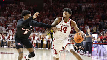 Mar 2, 2024; Norman, Oklahoma, USA; Oklahoma Sooners forward Jalon Moore (14) drives around Houston Cougars guard Mylik Wilson (8) during the second half at Lloyd Noble Center. Mandatory Credit: Alonzo Adams-Imagn Images