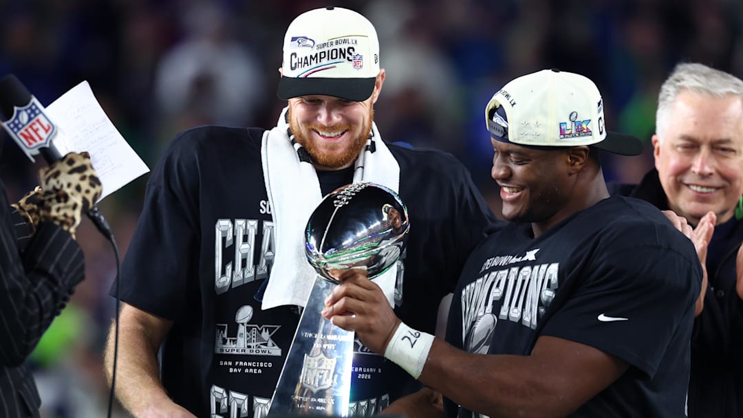 Feb 8, 2026; Santa Clara, CA, USA; Seattle Seahawks quarterback Sam Darnold (14) and running back Kenneth Walker III (9) celebrate with the Vince Lombardi trophy after defeating the New England Patriots in Super Bowl LX at Levi's Stadium. Mandatory Credit: Mark J. Rebilas-Imagn Images