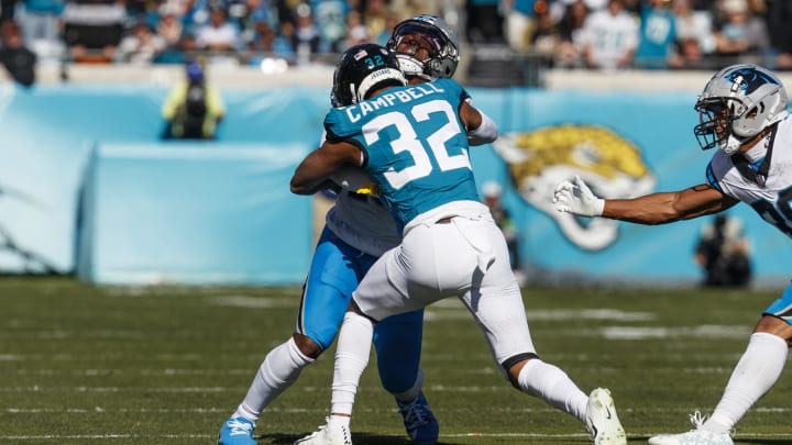 Dec 31, 2023; Jacksonville, Florida, USA; Jacksonville Jaguars corner back Tyson Campbell (32) tackles Carolina Panthers wide receiver Jonathan Mingo (15) during the first quarter at EverBank Stadium. Mandatory Credit: Morgan Tencza-USA TODAY Sports