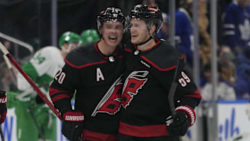 Mar 16, 2024; Toronto, Ontario, CAN; Carolina Hurricanes forward Sebastian Aho (20) congratulates forward Jake Guentzel (59) for scoring the winning goal against the Toronto Maple Leafs during the overtime shoot out at Scotiabank Arena. Mandatory Credit: John E. Sokolowski-Imagn Images