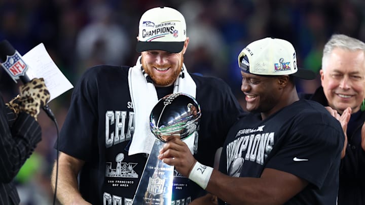 Sam Darnold and Kenneth Walker III celebrate with the Vince Lombardi trophy after defeating the Patriots in Super Bowl LX
