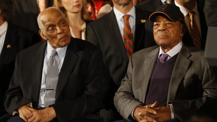 Jun 4, 2015; Washington, DC, USA; Baseball hall of famers Monte Irvin (left) and Willie Mays (right) and members of the San Francisco Giants listen during a ceremony honoring the World Series champion Giants in the East Room at the White House. 