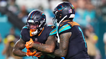 Sep 29, 2025; Miami Gardens, Florida, USA; Miami Dolphins quarterback Tua Tagovailoa (1) hands the ball off to running back Ollie Gordon II (31) against the New York Jets during the first half at Hard Rock Stadium. Mandatory Credit: Rich Storry-Imagn Images