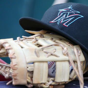 Apr 24, 2024; Atlanta, Georgia, USA; A detailed view of a Miami Marlins hat and glove in the dugout before a game against the Atlanta Braves at Truist Park. Mandatory Credit: Brett Davis-Imagn Images