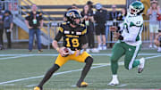 Jun 16, 2024; Hamilton, Ontario, CAN; Hamilton Tiger Cats quarterback Bo Levi Mitchell (19) is pursued by Saskatchewan Rough Riders defensive lineman Miles Brown (90) at Tim Hortons Field. Mandatory Credit: Gerry Angus-Imagn Images