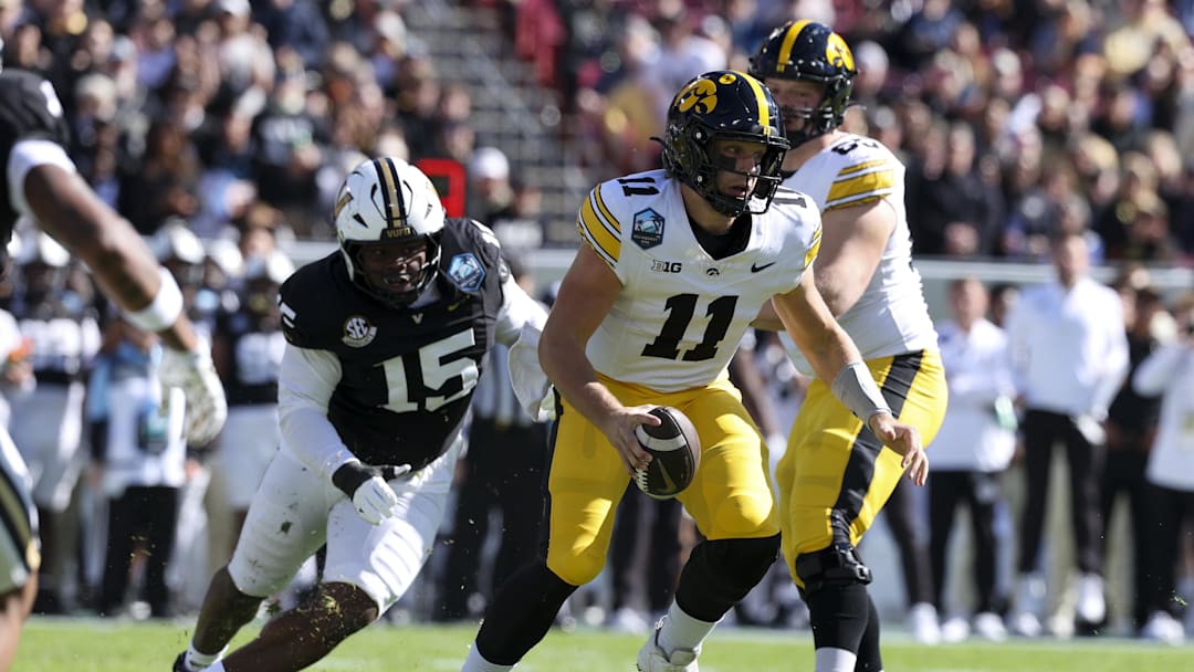 Dec 31, 2025; Tampa, FL, USA; Iowa Hawkeyes quarterback Mark Gronowski (11) scrambles out of the pocket against the Vanderbilt Commodores in the first quarter during the ReliaQuest Bowl at Raymond James Stadium. Mandatory Credit: Nathan Ray Seebeck-Imagn Images
