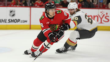 Mar 28, 2025; Chicago, Illinois, USA; Chicago Blackhawks center Connor Bedard (98) and Vegas Golden Knights left wing Brandon Saad (20) battle for control of the puck during the second period at United Center. Mandatory Credit: Talia Sprague-Imagn Images