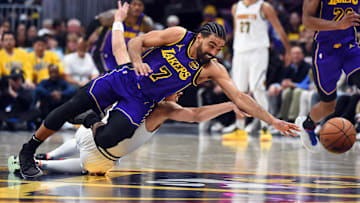 Feb 22, 2025; Denver, Colorado, USA; Los Angeles Lakers guard Gabe Vincent (7) dives for a loose ball after a steal from Denver Nuggets guard Julian Strawther (3) during the second half at Ball Arena. Mandatory Credit: Christopher Hanewinckel-Imagn Images