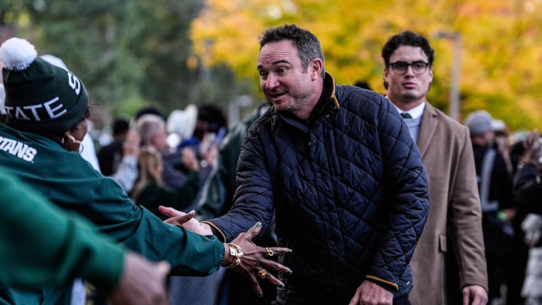 Michigan State head coach Jonathan Smith shakes hands with fans as the team walk towards the Spartan Stadium in East Lansing on Saturday, October 24, 2025.