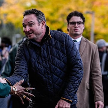 Michigan State head coach Jonathan Smith shakes hands with fans as the team walk towards the Spartan Stadium in East Lansing on Saturday, October 24, 2025.