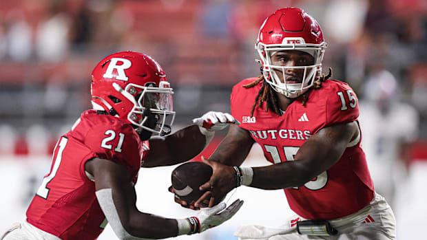 Rutgers Scarlet Knights quarterback Ajani Sheppard (15) looks to hand off to running back Antwan Raymond (21) during the seco