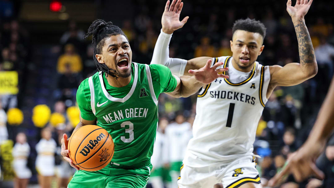Jan 29, 2025; Wichita, Kansas, USA;  North Texas Mean Green guard Jasper Floyd (3) drives to the basket around Wichita State Shockers guard Xavier Bell (1) during the first halfat Charles Koch Arena. Mandatory Credit: William Purnell-Imagn Images
