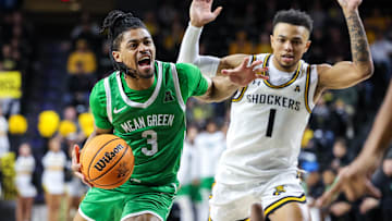 Jan 29, 2025; Wichita, Kansas, USA;  North Texas Mean Green guard Jasper Floyd (3) drives to the basket around Wichita State Shockers guard Xavier Bell (1) during the first halfat Charles Koch Arena. Mandatory Credit: William Purnell-Imagn Images