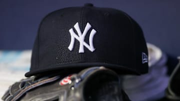 Aug 14, 2023; Atlanta, Georgia, USA; A detailed view of a New York Yankees hat and glove on the bench against the Atlanta Braves in the third inning at Truist Park. 