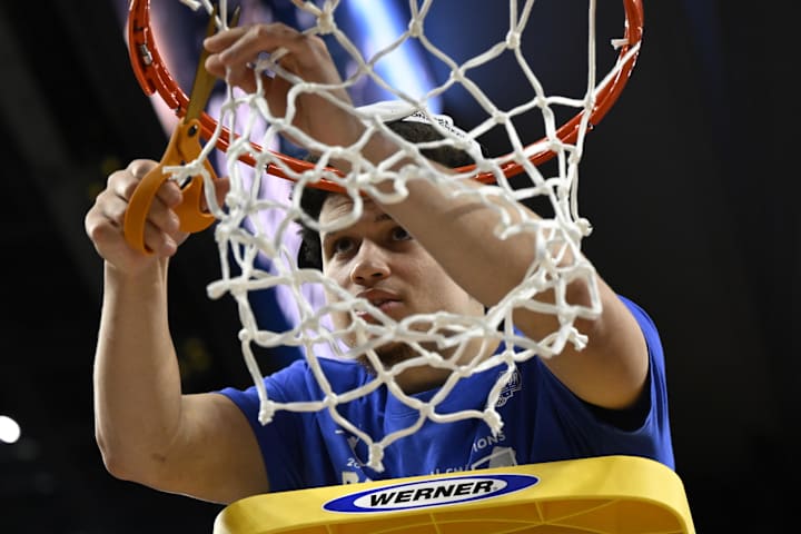 Florida Gators guard Walter Clayton Jr. cuts down the net after defeating the Texas Tech Red Raiders during March Madness. 