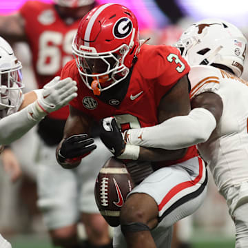 Dec 7, 2024; Atlanta, GA, USA; Georgia Bulldogs running back Nate Frazier (3) fumbles the ball against Texas Longhorns defensive back Andrew Mukuba (4) during the second half in the 2024 SEC Championship game at Mercedes-Benz Stadium. Mandatory Credit: Brett Davis-Imagn Images