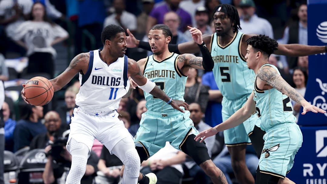 Dallas Mavericks guard Kyrie Irving controls the ball as Charlotte Hornets guard Nick Smith Jr. defends during the first half at American Airlines Center.