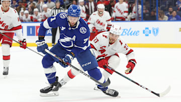 Sep 24, 2024; Tampa, Florida, USA; Tampa Bay Lightning center Anthony Cirelli (71) passes the puck as Carolina Hurricanes center Tyson Jost (27) defends during the first period at Amalie Arena. Mandatory Credit: Kim Klement Neitzel-Imagn Images