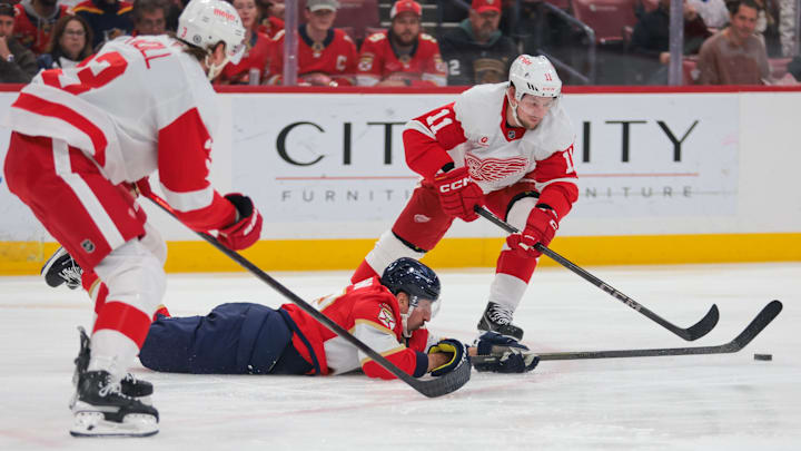Apr 10, 2025; Sunrise, Florida, USA; Florida Panthers center Brad Marchand (63) dives for the puck against Detroit Red Wings right wing Vladimir Tarasenko (11) during the first period at Amerant Bank Arena. Mandatory Credit: Sam Navarro-Imagn Images