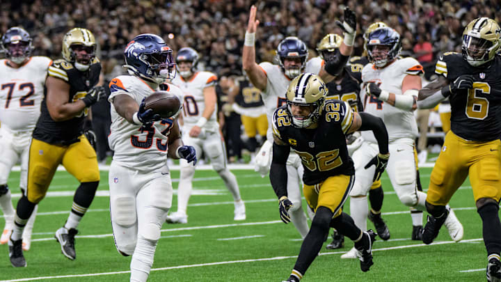 Oct 17, 2024; New Orleans, Louisiana, USA; Denver Broncos running back Javonte Williams (33) scores a touchdown against New Orleans Saints safety Tyrann Mathieu (32) during the second quarter at Caesars Superdome. Mandatory Credit: Matthew Hinton-Imagn Images