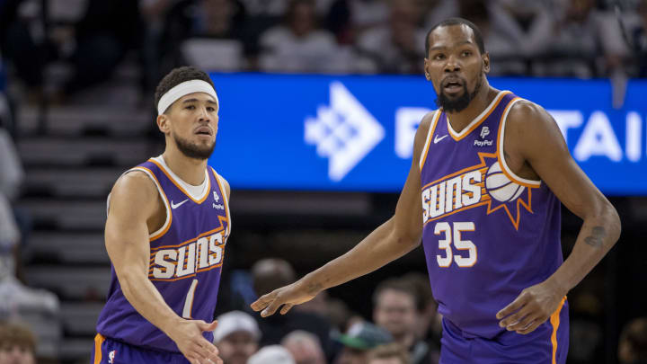 Apr 20, 2024; Minneapolis, Minnesota, USA; Phoenix Suns guard Devin Booker (1) shakes hands with forward Kevin Durant (35) against the Minnesota Timberwolves in the first half during game one of the first round for the 2024 NBA playoffs at Target Center. Mandatory Credit: Jesse Johnson-USA TODAY Sports