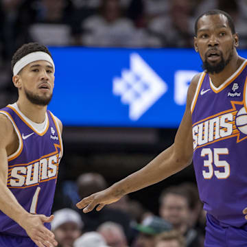 Apr 20, 2024; Minneapolis, Minnesota, USA; Phoenix Suns guard Devin Booker (1) shakes hands with forward Kevin Durant (35) against the Minnesota Timberwolves in the first half during game one of the first round for the 2024 NBA playoffs at Target Center. Mandatory Credit: Jesse Johnson-Imagn Images