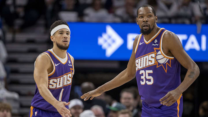 Apr 20, 2024; Minneapolis, Minnesota, USA; Phoenix Suns guard Devin Booker (1) shakes hands with forward Kevin Durant (35) against the Minnesota Timberwolves in the first half during game one of the first round for the 2024 NBA playoffs at Target Center. Mandatory Credit: Jesse Johnson-Imagn Images