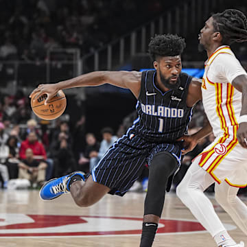 Apr 13, 2025; Atlanta, Georgia, USA; Orlando Magic forward Jonathan Isaac (1) dribbles against Atlanta Hawks guard Keaton Wallace (2) during the first half at State Farm Arena. Mandatory Credit: Dale Zanine-Imagn Images