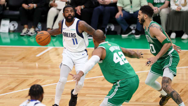 Jun 17, 2024; Boston, Massachusetts, USA; Dallas Mavericks guard Kyrie Irving (11) dribbles the ball against Boston Celtics center Al Horford (42) and forward Jayson Tatum (0) during the third quarter in game five of the 2024 NBA Finals at TD Garden. Mandatory Credit: Peter Casey-USA TODAY Sports