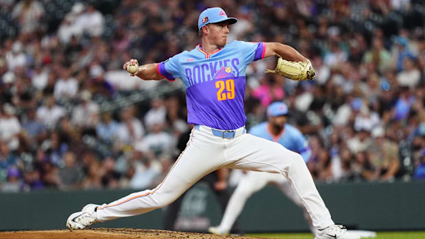Gordon getting ready to release a baseball off the pitching mound in a blue and purple jersey with white pant