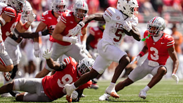 Texas Longhorns running back Quintrevion Wisner (5) runs past Ohio State Buckeyes defensive end Eddrick Houston (96) during the second half of the NCAA football game at Ohio Stadium on Aug. 30, 2025. Ohio State won 14-7.