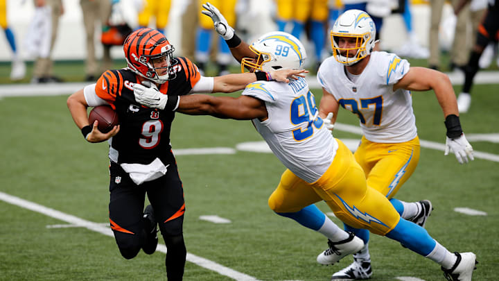 Sep 13, 2020; Cincinnati, OH, USA;  Cincinnati Bengals quarterback Joe Burrow (9) is pulled down by Los Angeles Chargers defensive tackle Jerry Tillery (99) in the first quarter of the NFL Week 1 game between the Cincinnati Bengals and the Los Angeles Chargers at Paul Brown Stadium in downtown Cincinnati on Sunday, Sept. 13, 2020.

Mandatory Credit: Sam Greene/Cincinnati Enquirer-USA TODAY NETWORK