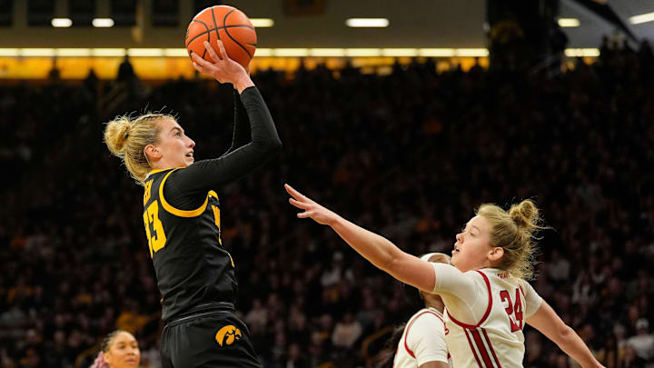 Iowa guard Lucy Olsen (33) shoots as Wisconsin guard Natalie Leuzinger (24) defends during a Big Ten conference game Sunday, March 2, 2025 at Carver-Hawkeye Arena in Iowa City, Iowa.